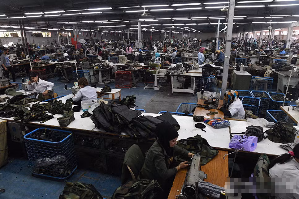 Trong ảnh là không khí nhộn nhịp trong xưởng may mặc quân trang.