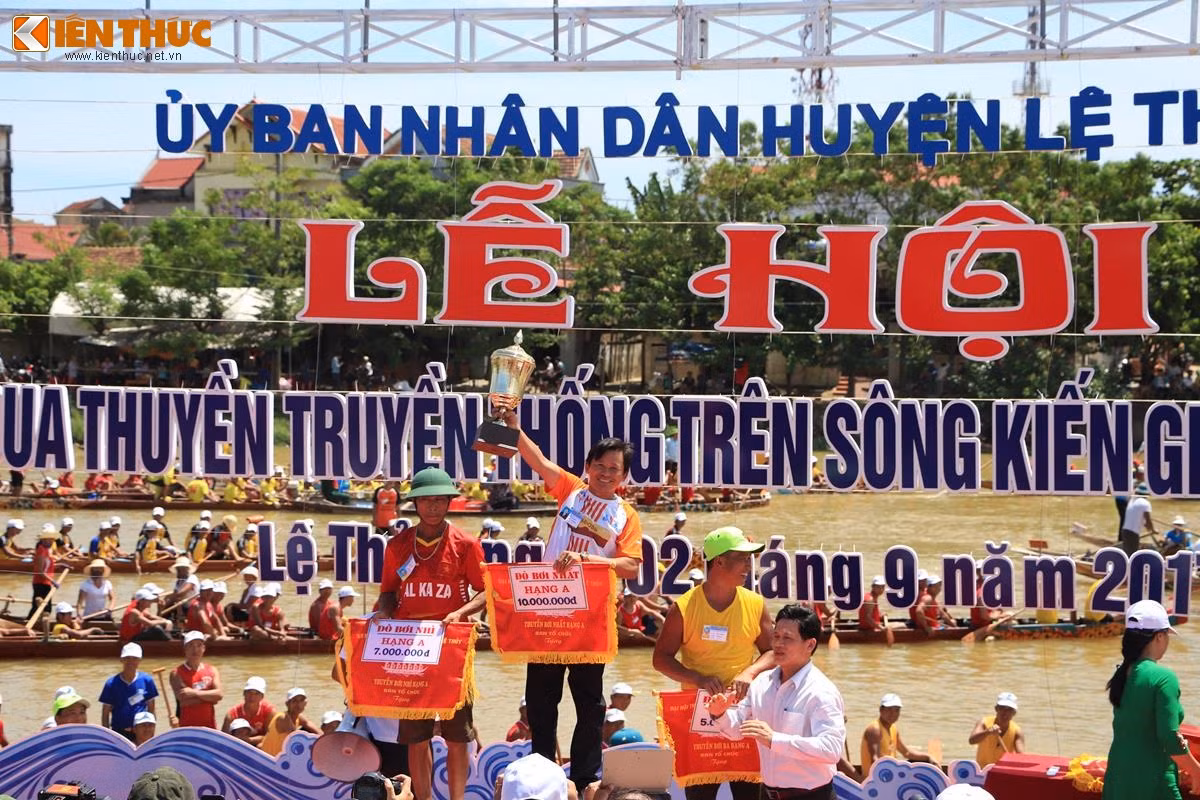 Đại diện đò bơi xã Mỹ Thủy nhận cờ lưu niệm và cúp vô địch hạng A. Giải thưởng tuy không lớn nhưng nó là niềm vinh dự và tự hào lớn cho các đội dành được thứ hạng cao. Ảnh: Quốc Minh.