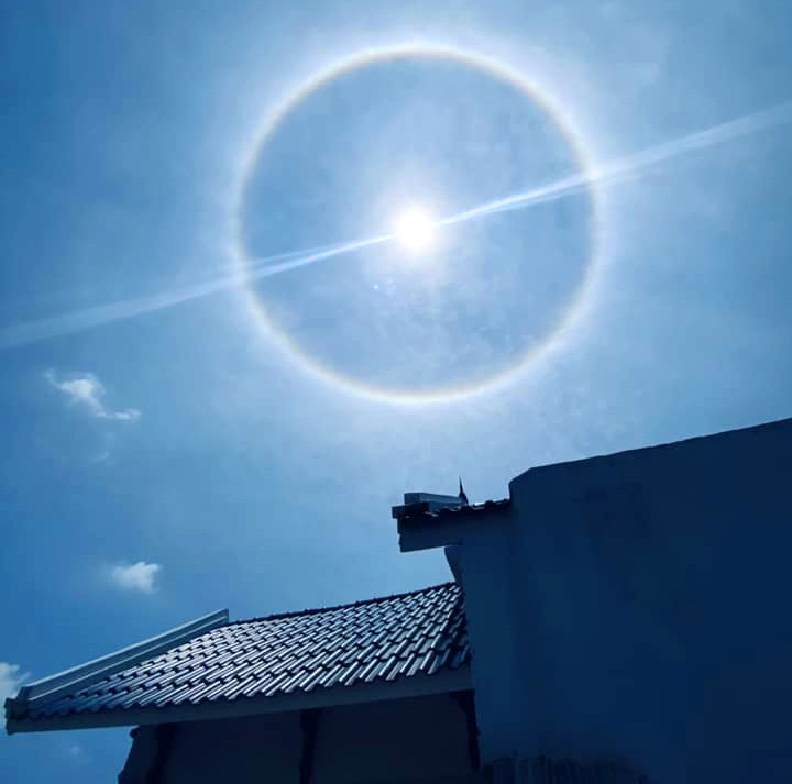 Các chuyên gia lý giải hào quang mặt trời xảy ra khi ánh sáng mặt trời tương tác với các tinh thể băng lơ lửng trong bầu khí quyển và tạo thành một quầng sáng màu trắng hoặc nhiều màu sắc đỏ, cam, vàng, lục, lam, chàm, tím. Ảnh: Móng Cái New.