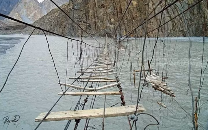  Cầu treo Hussaini, Pakistan - Hình ảnh của cây cầu này đã nói lên tất cả. Việc bước qua những tấm ván thưa và cây cầu đung đưa trên mặt nước này không dành cho những người yếu tim. Bạn có thể bị rơi xuống sông Hunza bất cứ lúc nào. Thêm vào đó, những gì còn sót lại của cây cầu treo cũ bên cạnh cũng đủ khiến bạn chùn bước.