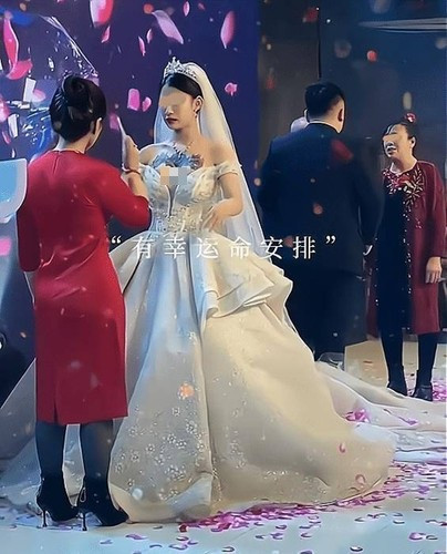 Theo đó, khi MC đám cưới mời bố mẹ chồng lên chúc phúc cho cặp đôi, mẹ chồng sắc mặt tối sầm, ngồi im mặc khách mời đổ dồn ánh mắt về phía mình. Sau khi người thân và bạn bè thuyết phục, mẹ chồng mới bước lên sân khấu. MC giục vài lần mẹ chồng mới miễn cưỡng lên tiếng, giải thích bản thân không khỏe nên để mọi người chờ lâu.