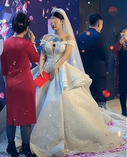 Cụ thể, cô dâu xuất hiện với thiết kế váy trắng, đầu đội vương miện, cài voan. Chiếc đầm không có gì đáng bàn, thậm chí có thể khen đẹp. Điều khiến mọi người chú ý là hình xăm lớn vùng ngực cô dâu. So với khách mời ăn mặc chỉn chu (nam giới mặc vest, phụ nữ mặc đầm đỏ kín đáo) thì hình xăm lớn trên ngực cô dâu không ăn nhập. Sự khác biệt này khiến mẹ chồng có hành động gây bất ngờ.