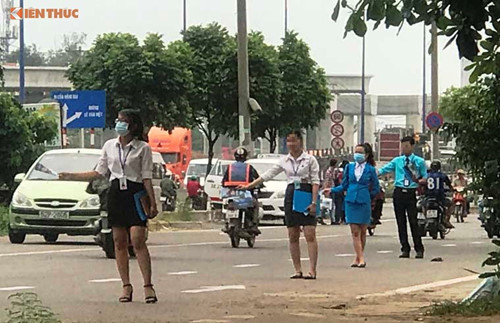 Nhóm thanh niên đứng xuống đường để phát tờ rơi, quảng cáo cho dự án căn hộ SAIGON GATEWAY. Ảnh: Vũ Sơn.