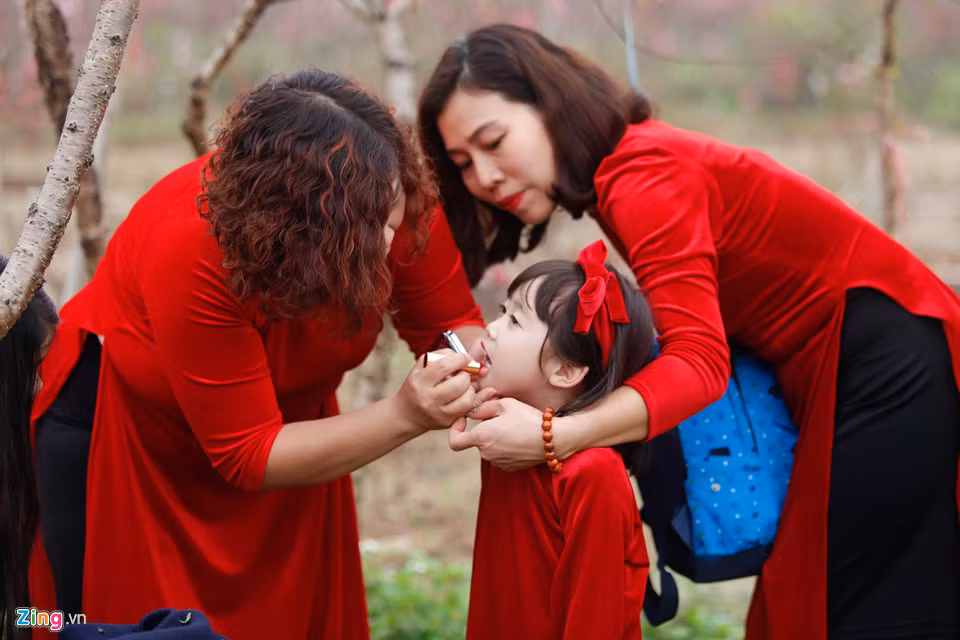 Không chỉ người lớn, nhiều em nhỏ cũng được bố mẹ đưa đến vườn đào để chụp hình. “Bé nhà mình cực kỳ thích mặc áo dài. Vì thế, mình đã dành thời gian lựa chọn để đáp ứng mong muốn của con. Đồng thời, bản thân mình cũng thấy việc cho con mặc áo dài cũng như một cách để dạy con nhiều hơn về truyền thống của dân tộc", chị Thanh Mai (Hai Bà Trưng, Hà Nội) chia sẻ.