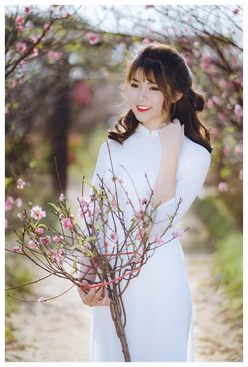 Nữ sinh 10x diện áo dài trắng tinh khôi , hòa với sắc hồng của vườn đào tạo nên những bức ảnh hài hòa như tranh vẽ.