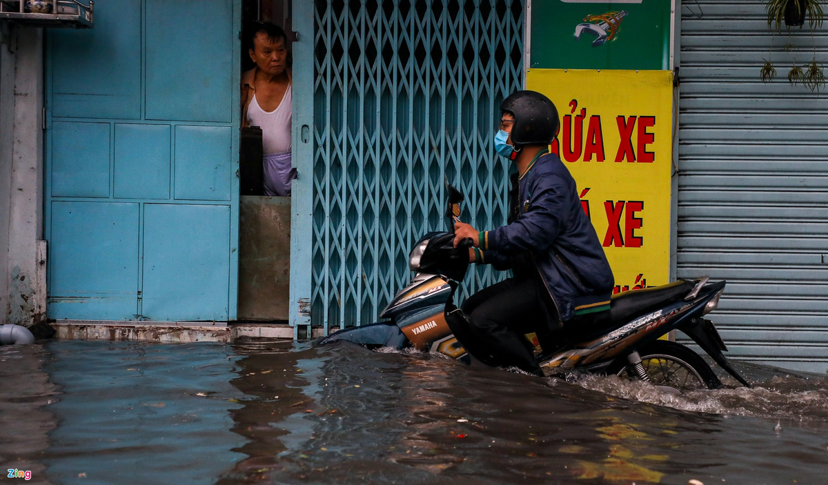 Để tránh dòng nước xiết, nhiều người phải dắt xe lên vỉa hè.