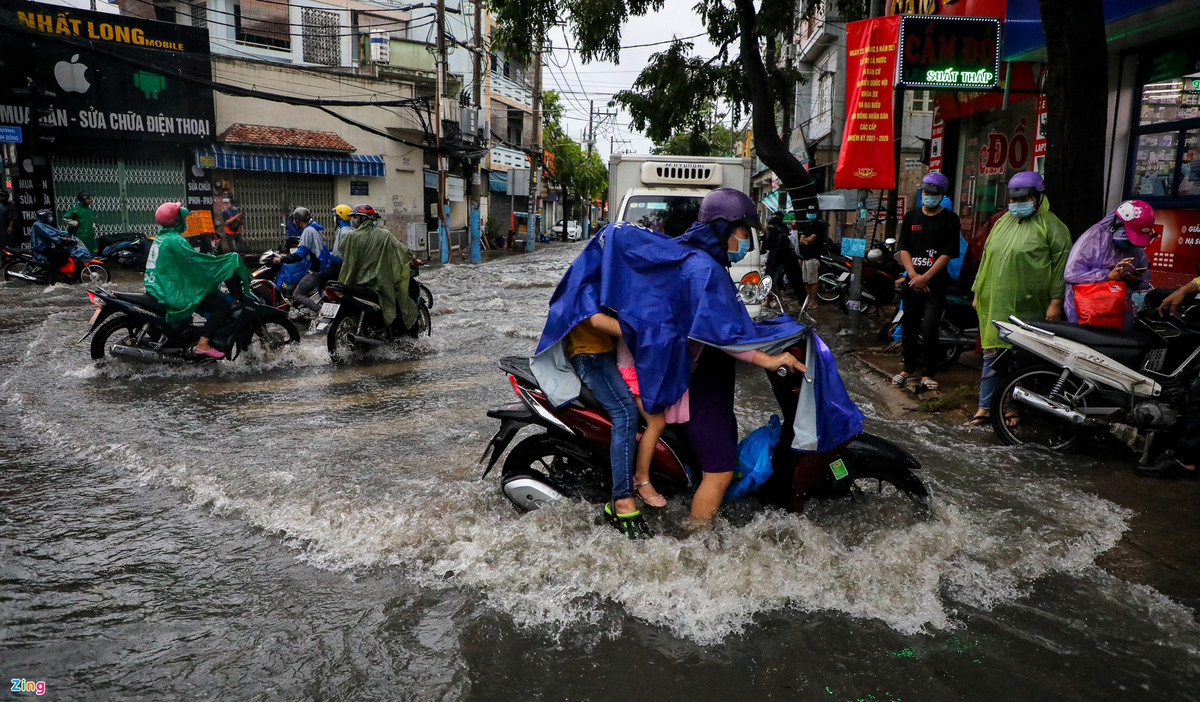 Dòng nước chảy mạnh khiến nhiều người đi xe máy qua khu vực này loạng choạng tay lái. 