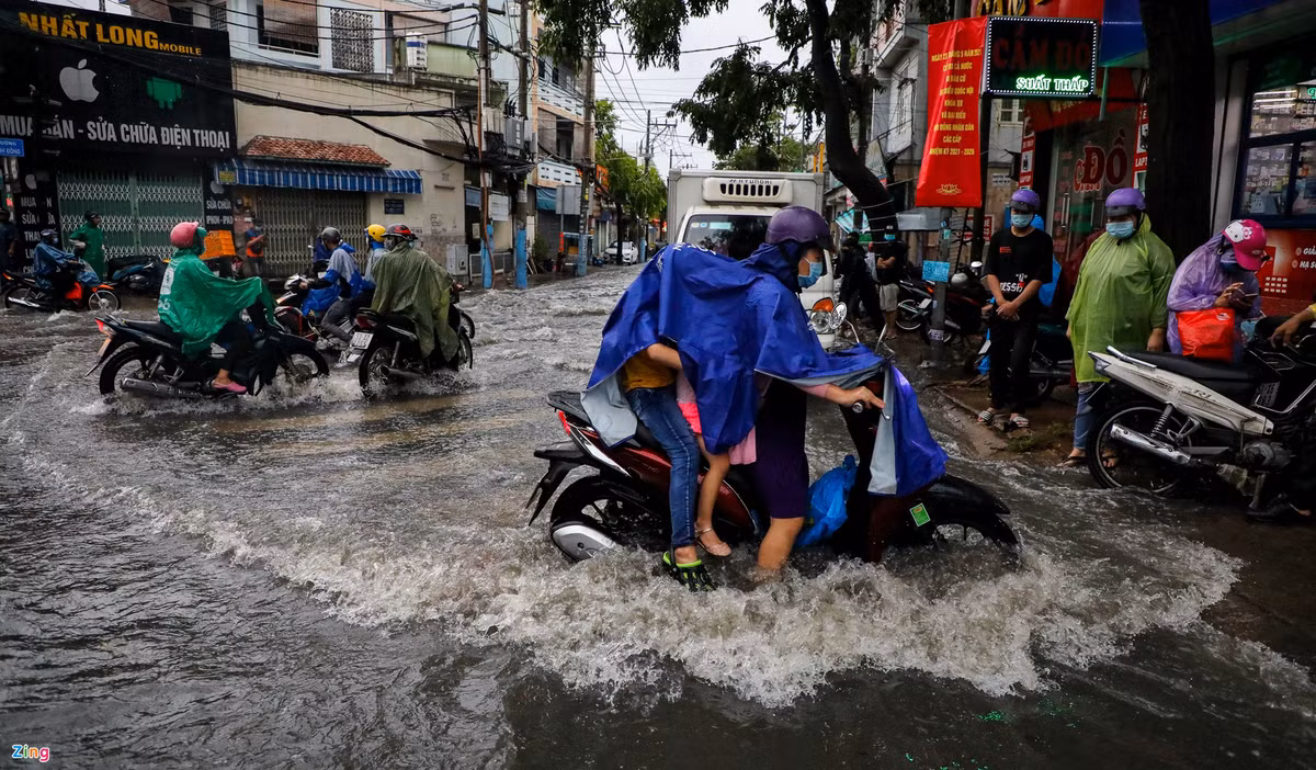 Dòng nước chảy mạnh khiến nhiều người đi xe máy qua khu vực này loạng choạng tay lái. 