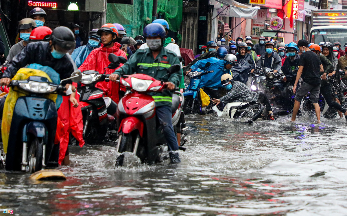 Mưa như trút cộng với độ dốc lớn của đường tạo thành dòng chảy xiết khiến một số người đứng chờ nước rút cũng bị té ngã.