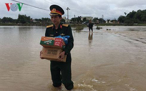 Các chiến sỹ Ban Chỉ huy Quân sự thị xã An Nhơn mang quà Bộ Quốc phòng vào tặng gia đình anh Nghĩa.