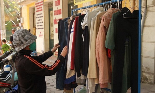 Cô Nguyễn Thị Na Na lựa chọn áo quần từ quầy hàng miễn phí cho người nghèo trên đường Quán Sứ. Ảnh: Hoàng Hiệp.