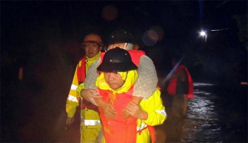 Công an Quảng Bình cõng người già đi tránh lũ trong đêm 14/10. Nguồn ảnh: Gia đình &amp; Pháp luật.