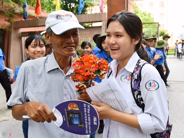 Hình ảnh cháu gái tươi tắn nhận bó hoa của ông tặng sau giờ thi đại học căng thẳng là điểm nhấn đẹp trong kỳ thi tuyển sinh đại học - cao đẳng 2016. Ông Phạm Minh Đức (73 tuổi, ở quận Hà Đông, Hà Nội), trong lúc chờ đợi cháu mình làm bài thi, đã nhặt những bông hoa mà các công nhân vệ sinh môi trường bỏ đi trong quá trình cắt tỉa ở vườn Đại học Thủy Lợi, tỉ mỉ bó lại để tặng cháu. Ảnh: Zing.