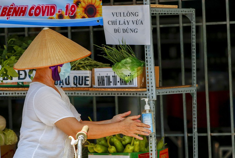 Trước khi nhận thực phẩm, tất cả người dân đều phải sát khuẩn tay.