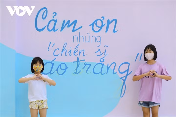 Các em nhỏ được bố mẹ tranh thủ chụp cho kiểu ảnh kỷ niệm với các bức bích hoạ.