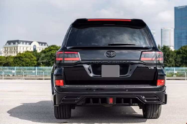Di chuyển ra phía sau, cụm đèn hậu của Toyota Land Cruiser 200 series được "lên đời" full LED và tối màu, trong khi cản dưới có thêm khuếch tán gió, đi kèm hệ thống ống xả giả nhằm tăng tính thẩm mỹ cho xe. Đáng chú ý, dòng chữ "Land Cruiser" ở nắp cốp cũng được sơn đen thể thao.