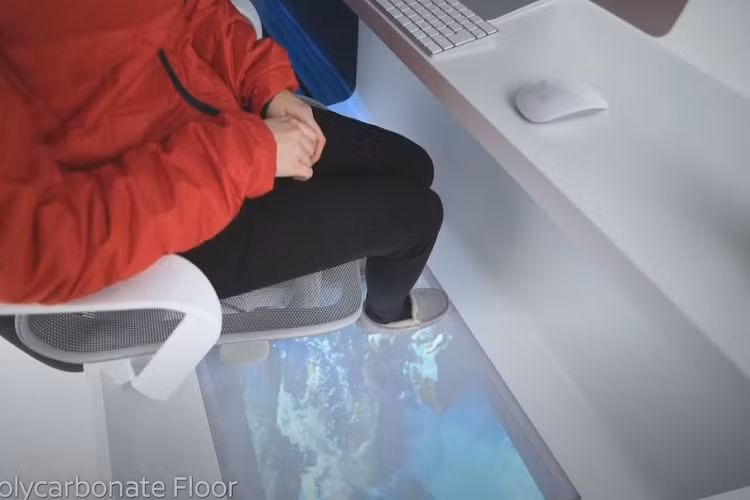 Nếu bạn đang ở ngoài trời, bạn có thể trượt toàn bộ văn phòng ra bên ngoài xe van bằng cách sử dụng một ứng dụng trên điện thoại thông minh. Về mặt kỹ thuật, bạn không thật sự ở bên ngoài, nhưng mặt sàn kéo dài ra ngoài từ cửa sau, do vậy bạn vẫn có thể cảm nhận được không khí trong lành hoặc thậm chí nghiêng mình một chút để có tầm nhìn đẹp hơn. Mặt sàn chất liệu polycarbonate cũng giúp bạn cảm thấy như thể đang thực sự ở ngoài tự nhiên.