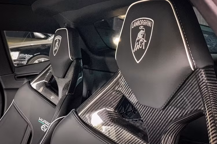 Mở cửa bước vào trong khoang lái, siêu xe Lamborghini Huracan EVO RWD đầu tiên về nước được chủ nhân chọn lựa ghế ngồi dạng đua với phần khung hoàn toàn từ sợi carbon kết hợp thêm da cao cấp cùng điểm nhấn chính là dây an toàn đua và dòng chữ Huracan EVO màu trắng trên lưng ghế. Xe còn có nhiều chi tiết hoàn thành màu trắng và cả sợi carbon để tạo điểm nhấn ở ngoại hình.