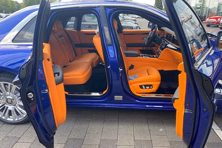 Cụ thể, chiếc xe siêu sang Rolls-Royce Ghost 2021 được người này "nhá hàng" với các đại gia Việt sở hữu bộ áo xanh dương rất nổi bật, kết hợp với đó là các chi tiết mạ crôm và quan trọng hơn là đường kẻ coachline được các nghệ nhân của Rolls-Royce dùng đuôi ngựa để thực hiện lại có tông màu cam chạy dài bên hông xe rất ấn tượng.