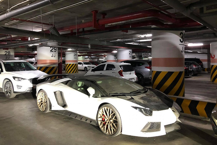 Trong đó, những hình ảnh do một cư dân mạng mới đây chia sẻ lên mạng xã hội cho thấy, chiếc siêu xe Lamborghini Aventador LP700-4 Roadster của một doanh nhân Hà Nội bị bắt gặp dưới hầm đỗ xe của một trung tâm thương mại với ngoại thất bám bụi dày đặc. Đây là một trong những chiếc siêu xe độ đẹp nhất Việt Nam nhưng không rõ vì lý do là gì đã khiến cho "chú bò tót" Lamborghini Aventador LP700-4 Roadster độ khủng này bị chủ nhân "bỏ rơi" dưới hầm đỗ xe dẫn đến ngoại thất bám đầy bụi.