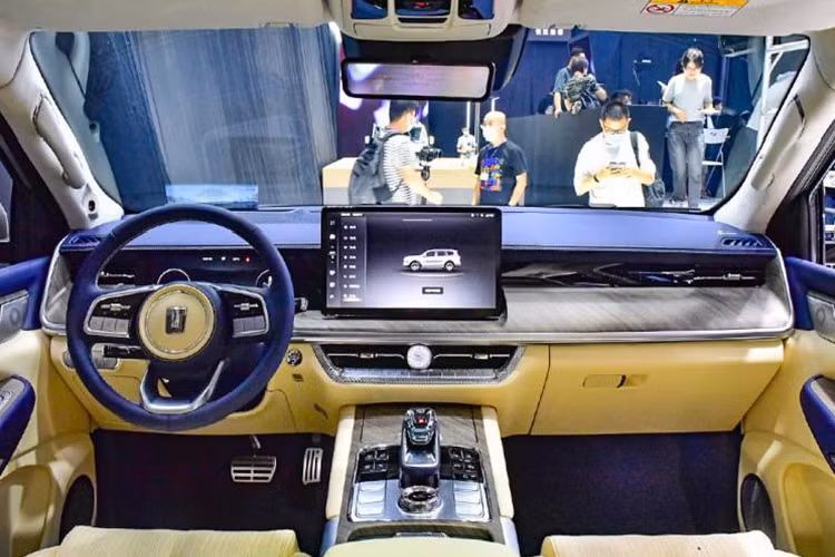Trước mặt người lái là vô lăng bọc da phối 2 màu, tích hợp phím chức năng và bảng đồng hồ kỹ thuật số toàn phần với màn hình LCD không viền. Bên cạnh đó là màn hình thông tin giải trí dạng cảm ứng nằm độc lập trên mặt táp-lô với viền khá mỏng. Khu vực xung quanh màn hình trung tâm đều được ốp gỗ, tạo cảm giác vừa công nghệ cao vừa cổ điển.