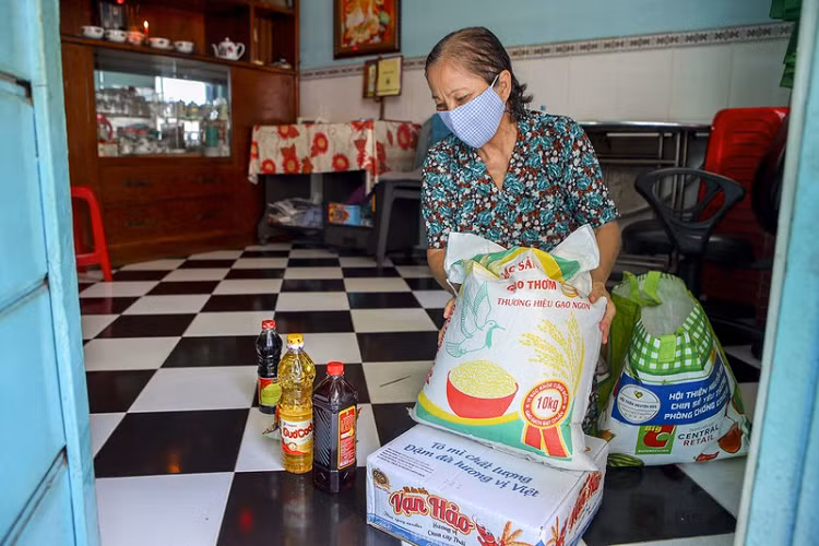 Mỗi túi quà gồm có mì gói, gạo, nước tương, nướng mắm... Bộ đội chia nhau mang đến từng hộ, mỗi dãy mất khoảng 20 phút để phân phát. 