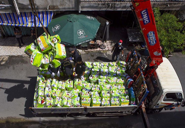 Mỗi xe chở khoảng 400 phần quà, đặt giữa 2 block chung cư, để chuyển lên các hộ dân lầu 1 đến lầu 4 bằng cẩu gắn rơ móc. 