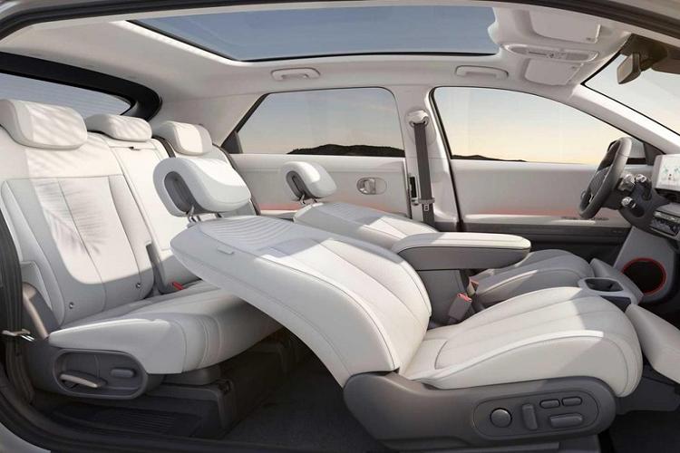 Chưa hết, Hyundai Ioniq 5 còn có cần số nằm sau vô lăng và màn hình hiển thị thông tin kính lái, hỗ trợ công nghệ thực tế ảo. Thêm vào đó là cụm điều khiển trung tâm của hàng ghế trước có thể trượt lên/xuống trong khoảng cách 140 mm. Trang bị này sẽ tiện dụng trong những bãi đỗ xe chật hẹp. Lúc đó, tài xế có thể trượt cụm điều khiển trung tâm về phía sau rồi ra khỏi xe thông qua cửa bên ghế phụ lái và ngược lại.