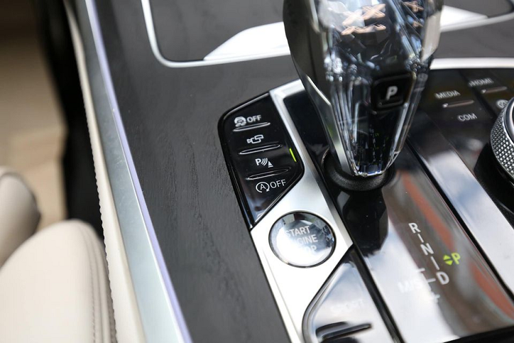 Sự đặc biệt trên BMW X7 chính là chiếc cần số làm từ pha lê trong suốt, bên trong có chữ X nổi bật. Trên cần số điện tử này có nút về P tiện dụng. Bên cạnh là nút khởi động thông minh, cụm điều khiển màn hình giải trí phía trên, phanh tay điện tử, tắt bật công nghệ auto hold, chọn chế độ lái gồm Eco, Comfort, Sport và một số tính năng khác.