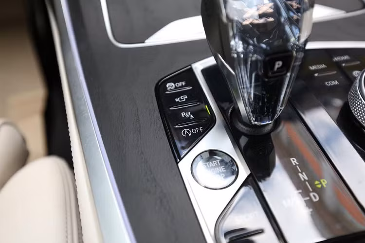 Sự đặc biệt trên BMW X7 chính là chiếc cần số làm từ pha lê trong suốt, bên trong có chữ X nổi bật. Trên cần số điện tử này có nút về P tiện dụng. Bên cạnh là nút khởi động thông minh, cụm điều khiển màn hình giải trí phía trên, phanh tay điện tử, tắt bật công nghệ auto hold, chọn chế độ lái gồm Eco, Comfort, Sport và một số tính năng khác.