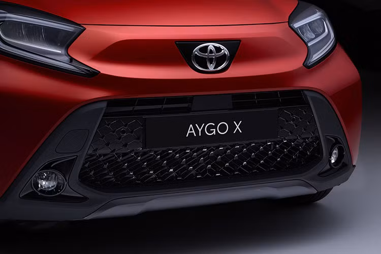 Trên đầu xe, Toyota Aygo X 2022 được trang bị lưới tản nhiệt hình lục giác khá lớn và nằm thấp bên dưới. Ở hai bên lưới tản nhiệt này là cặp đèn sương mù trước hình tròn. Phía trên xuất hiện cụm đèn pha LED, được bao quanh bằng dải đèn LED định vị ban ngày.