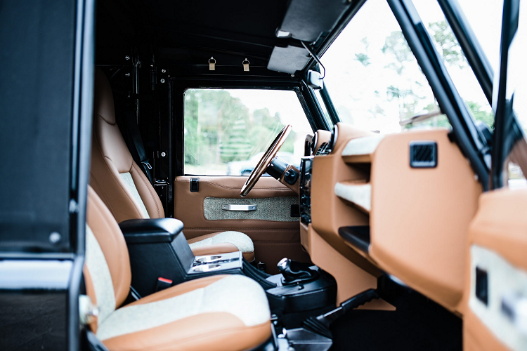 Khoang lái của chiếc Land Rover Defender 90 đời 1997 sang trọng và tiện nghi hơn nhưng vẫn giữ được thiết kế truyền thống của xe nguyên bản. Cabin được nâng cấp bằng việc bọc da và ốp gỗ, đi kèm là vải dệt cho cảm giác cao cấp.