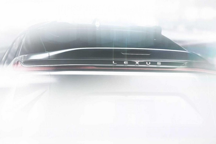 Bên sườn, Lexus RZ được thiết kế mượt mà và đi kèm nóc dốc về phía sau theo phong cách xe coupe. Có vẻ như cổng sạc của mẫu xe này nằm ở vị trí giữa chắn bùn trước và cửa bên ghế lái. Thêm vào đó là đường dập gân kéo dài từ chắn bùn trước đến cửa sau và bộ vành đa chấu. Đằng sau Lexus RZ xuất hiện cụm đèn hậu nối liền với nhau, vắt ngang đuôi xe. Nằm ngay bên trên đèn hậu là tem chữ nổi Lexus thay cho logo của hãng này.