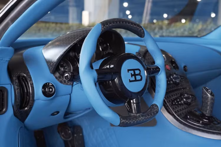 Cùm phanh của xe cũng được sơn màu xanh giống với màu sắc trên chiếc Chiron cùng chữ Bugatti được vẽ thủ công với màu bạc. Toàn bộ khoang nội thất nguyên bản trên xe đã được bọc lại, loại bỏ hoàn toàn các tấm da cũ màu đen và trắng. Hãng độ quyết định lựa chọn chất liệu da màu xanh sáng lấy cảm hứng từ Bugatti Chiron, các họa tiết chữ V trên ghế cũng được loại bỏ hoàn toàn, thay vào đó chính là các họa tiết đan chéo mới được đội ngũ thủ công của hãng độ phác họa ra và áp dụng lên xe.