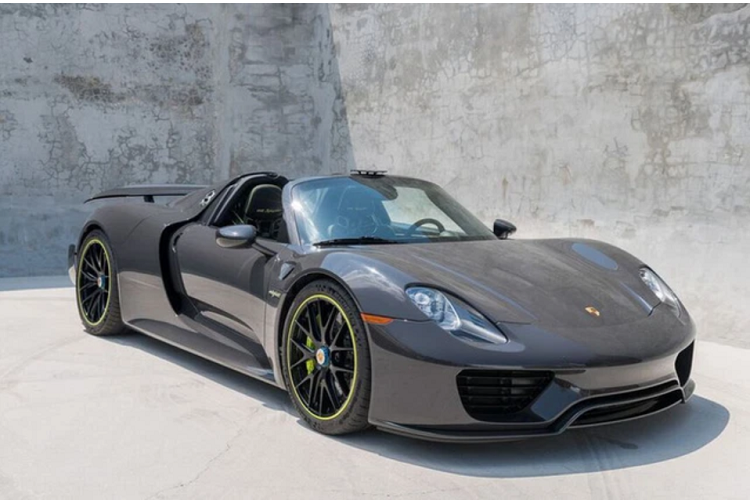 Chiếc xe hypercar Porsche 918 Spyder được tung tin đang trên đường về nước có ngoại thất sơn màu xám rất đẹp mắt, xe còn có nhiều chi tiết carbon và logo 918 Spyder màu xanh dạ quang.