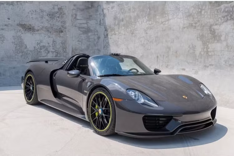Chiếc xe hypercar Porsche 918 Spyder được tung tin đang trên đường về nước có ngoại thất sơn màu xám rất đẹp mắt, xe còn có nhiều chi tiết carbon và logo 918 Spyder màu xanh dạ quang.