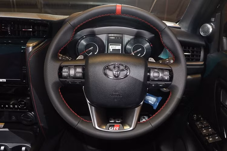 Tương tự như vậy, cần số của xe cũng được bọc bằng da nhân tạo và ốp màu bạc ám khói. Khu vực còn lại của cụm điều khiển trung tâm được ốp giả sợi carbon nhằm tăng vẻ thể thao.