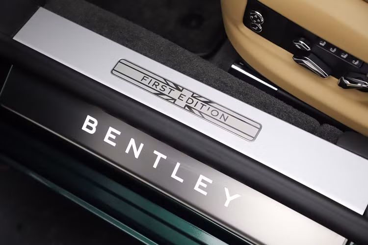 Mở cửa bước vào trong khoang lái, những dấu hiệu đặc biệt của dòng xe Bentley Flying Spur First Edition 2021 sẽ thể hiện ngay lập tức ở bậc cửa với dòng chữ Bentley phát sáng và phía trên còn có dòng chữ First Edition lồng vào trong logo cờ Anh. Ngoài ra Logo hình quốc kỳ Anh với số 1 còn xuất hiện trên bảng táp-lô, trước mặt ghế phụ của xe Bentley Flying Spur First Edition 2021.