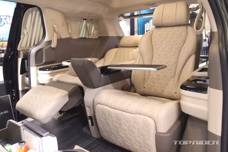 Thêm vào đó là màn hình cảm ứng 7 inch nằm trên bệ tì tay ở giữa 2 ghế sau. Ở bệ tì tay này còn có 2 chiếc bàn để hành khách ăn uống hoặc làm việc. Đó là chưa kể đến ngăn làm mát/hâm nóng đồ uống và ngăn đựng đồ dành cho hành khách.