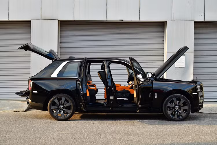 Mở cửa bước vào trong khoang lái, nội thất chiếc SUV siêu sang Rolls-Royce Cullinan gây choáng ngợp trước tông màu cam sặc sỡ. Bên cạnh đó, còn có nhiều chi tiết sơn đen hay ốp gỗ cao cấp.