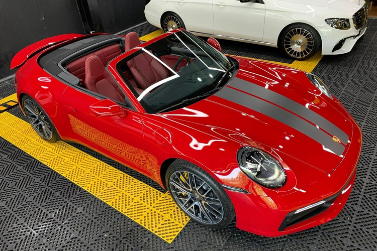 Ngoại hình xe Porsche 911 Carrera S Cabriolet có phần nắp capo được thiết kế hơi cong nhẹ và nối tiếp liền mạch với cụm đèn LED hình oval rất ấn tượng kết hợp đèn LED ban ngày để đảm bảo an toàn. Xe sở hữu cặp ống xả sơn đen nhám và logo tên Porsche được sơn đen tạo điểm nhấn với màu đỏ của xe.