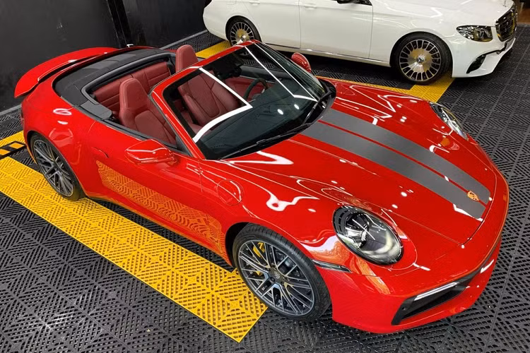 Ngoại hình xe Porsche 911 Carrera S Cabriolet có phần nắp capo được thiết kế hơi cong nhẹ và nối tiếp liền mạch với cụm đèn LED hình oval rất ấn tượng kết hợp đèn LED ban ngày để đảm bảo an toàn. Xe sở hữu cặp ống xả sơn đen nhám và logo tên Porsche được sơn đen tạo điểm nhấn với màu đỏ của xe.