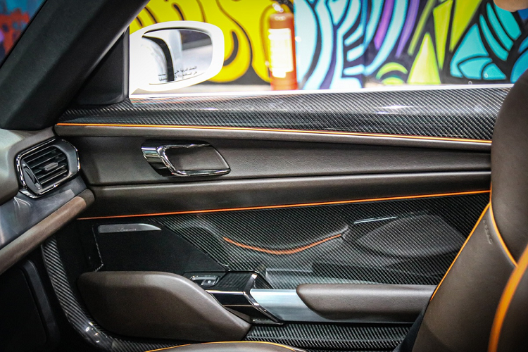 Nội thất của xe được bọc trong da màu nâu, kết hợp với các điểm nhấn màu cam. Vật liệu carbon sử dụng khá nhiều trên ghế, cửa xe, bậc cửa.