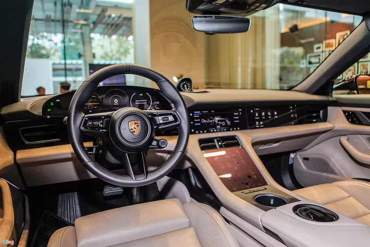 Bên trong, khoang lái được phối màu nâu và beige đồng điệu với ngoại thất. Cabin của Taycan nhìn chung có thiết kế thể thao và trực quan đặc trưng của Porsche. Điểm khác biệt chính là nội thất mẫu xe điện có rất ít nút bấm vật lý, hầu hết việc sử dụng tiện ích được thao tác thông qua các màn hình cảm ứng.