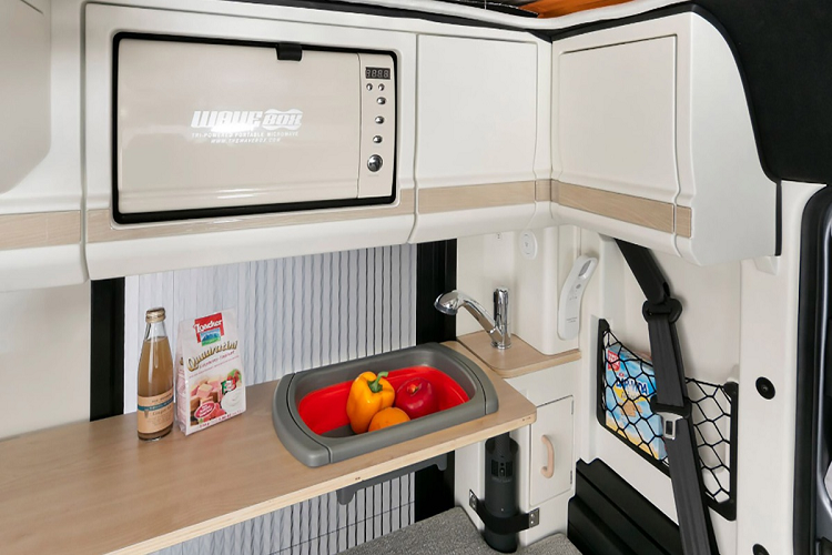 Khu vực phía sau của khoang xe có thể bố trí thành một gian bếp nhỏ với vòi nước, bồn rửa, tủ lắp lò vi sóng, bàn ăn... Đây là 1 trong 3 kiểu thiết kế nội thất mà Honda cung cấp cho N-Van Compo.