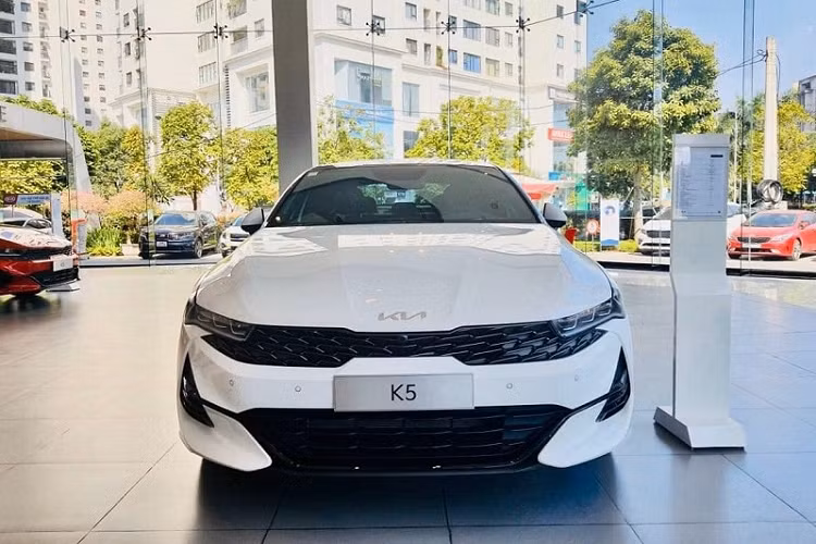 Phần đầu xe vẫn là bộ lưới tản nhiệt hình mũi hổ đặc trưng nhưng được mở rộng hơn sang hai bên, chạy liền mạch với cụm đèn trước gồm 3 bóng LED Projector tích hợp dải LED chiếu sáng ban ngày tạo hình góc cạnh. Hốc hút gió trung tâm cũng có kiểu tạo hình lưới sơn đen, với đường viền màu đen kéo dài đến hốc đèn sương mù ở hai bên. Chiếc Kia K5 thế hệ mới này còn được trang bị cảm biến trước và camera 360 độ.