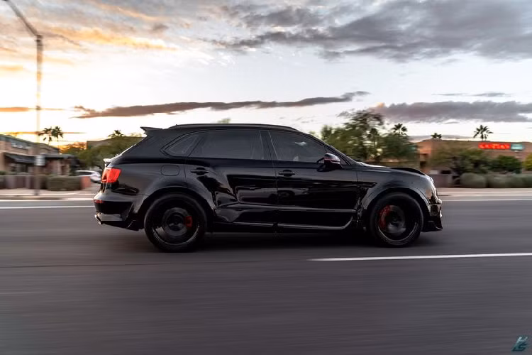 Chiếc SUV siêu sang Bentley Bentayga được hoàn thiện trong lớp sơn đen huyền bí kết hợp với một số điểm nhấn màu đỏ, tạo hiệu ứng thẩm mỹ thú vị. Xe được trang bị mâm xe Onyx 23 inch, bọc gọn trong bộ lốp Continental.