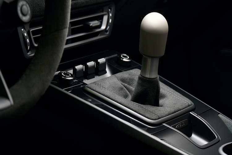 Khoang nội thất của xe được phối chủ yếu với chất liệu da cao cấp màu đen với một số chi tiết màu vàng tạo điểm nhấn như phần viền đánh dấu tâm vô lăng, logo trang trí bên táp lô phải của xe cùng logo "Le Mans 1985" với hình đường đua được thêu trên tựa đầu của xe. Chi tiết cần số trên xe gợi nhớ đến chi tiết cần số được làm bằng magiê trên chiếc xe đua 956. Phần trên của cần số này được đúc từ một khối nhôm và bề mặt của cần số được đánh nhám và hoàn thiện với bề mặt nhẵn độc đáo.