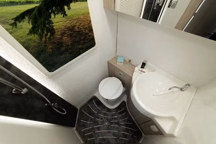 Vị trí phía sau của cửa cho phép bạn tận hưởng một nhà bếp khá rộng rãi, bất kể kích thước tổng thể nhỏ bé của chiếc RV. Nhà bếp có đủ chỗ cho bếp 2 lò, bồn rửa có nắp, và một tủ lạnh nhỏ. Đối diện với khu vực nhà bếp, bạn sẽ tìm thấy một bàn ăn hình chữ L với khả năng chuyển đổi thành một không gian ngủ bổ sung.