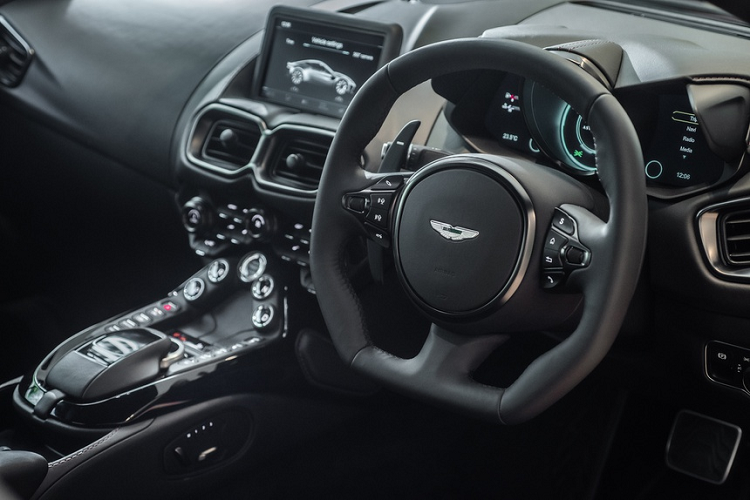 Khoang lái Vantage cũng được tô điểm bằng các đường chỉ thêu đỏ. Logo của hãng xe Anh Quốc được thêu màu đỏ. Màu đen vẫn là tông màu chủ đạo.